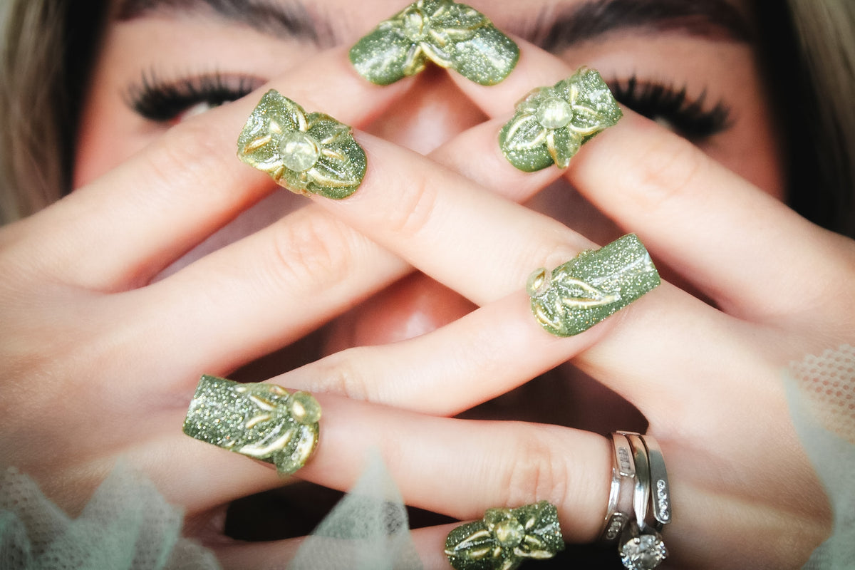 Green Blossom press-on nails with green glitter with raised gold-outlined clear flowers.